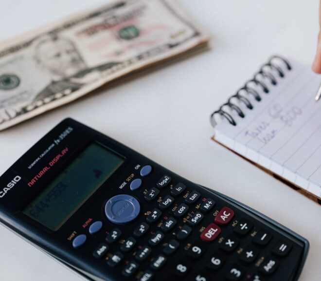 crop unrecognizable accountant counting savings using notebook and calculator
