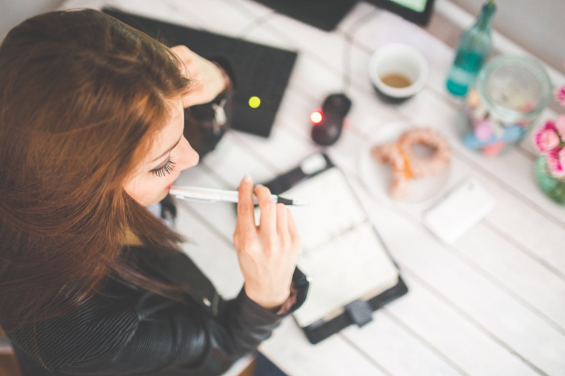 young woman thinking with pen while preparing for a job interview