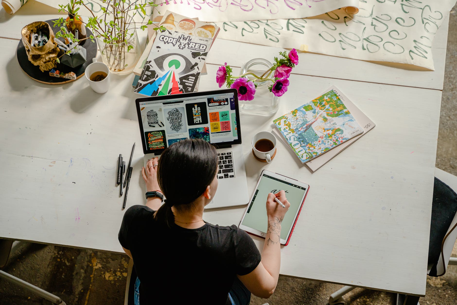 Starting a job photo of woman writing on tablet computer while using laptop