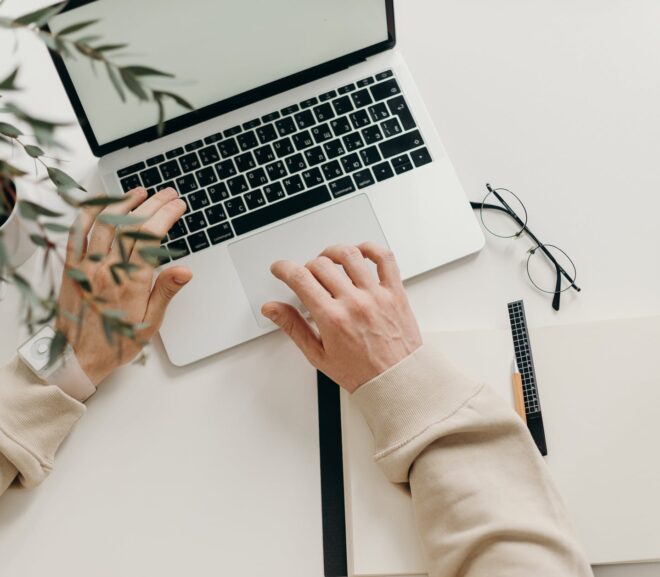 person in beige long sleeve shirt using macbook pro