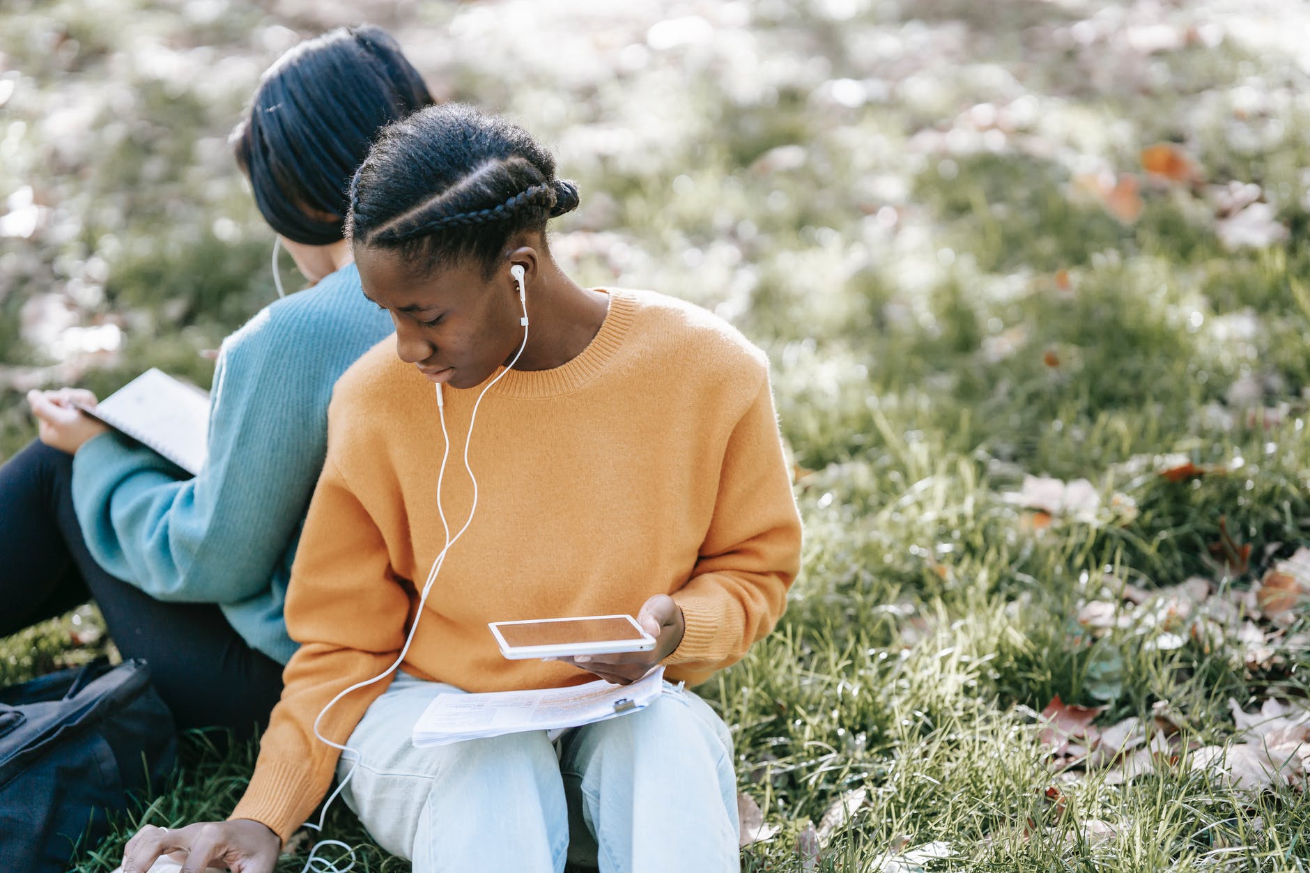 multiethnic women using tablet and reading in park listening to 19 empowering and inspiring podcasts