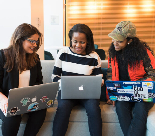 Three women discussing over their computers