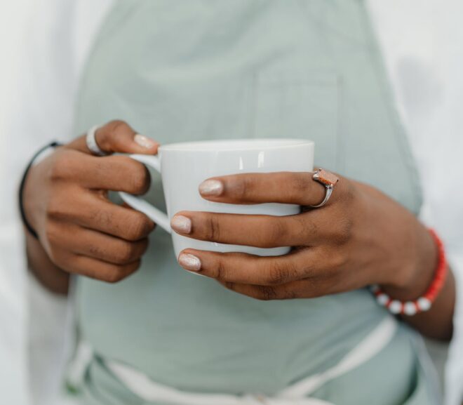 crop young black woman in apron in coffee shop