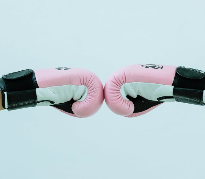 faceless people in boxing gloves giving fist bump in studio
