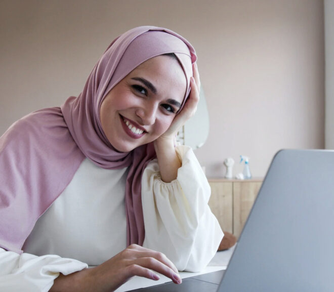 Women smiling behind laptop