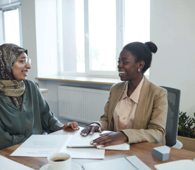 2 women sitting at an office desk