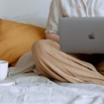 anonymous woman using laptop in bedroom