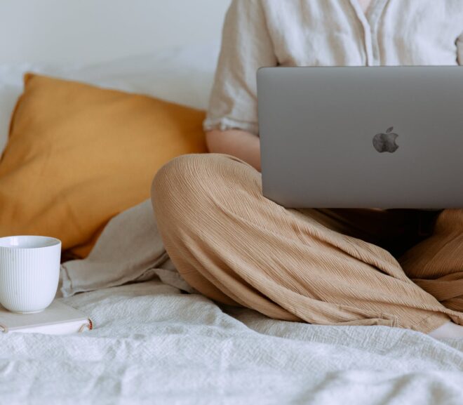 anonymous woman using laptop in bedroom